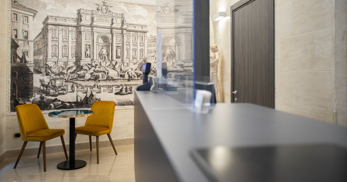 Hotel Fellini, ambiente con quadro di Roma, bancone e tavolini | LocaliArreda