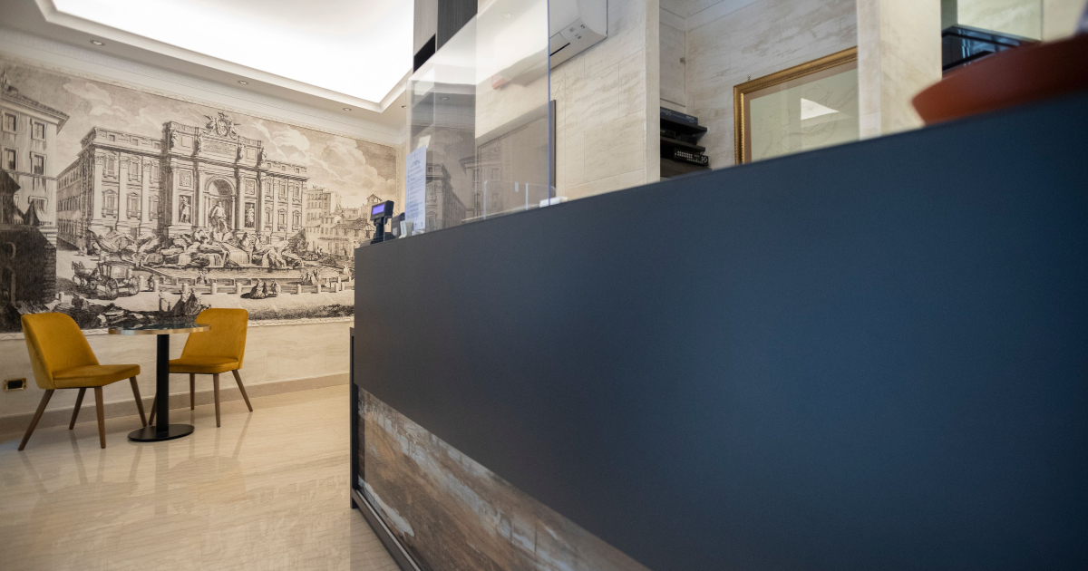 Hotel Fellini, ambiente reception con bancone e tavolini | LocaliArreda