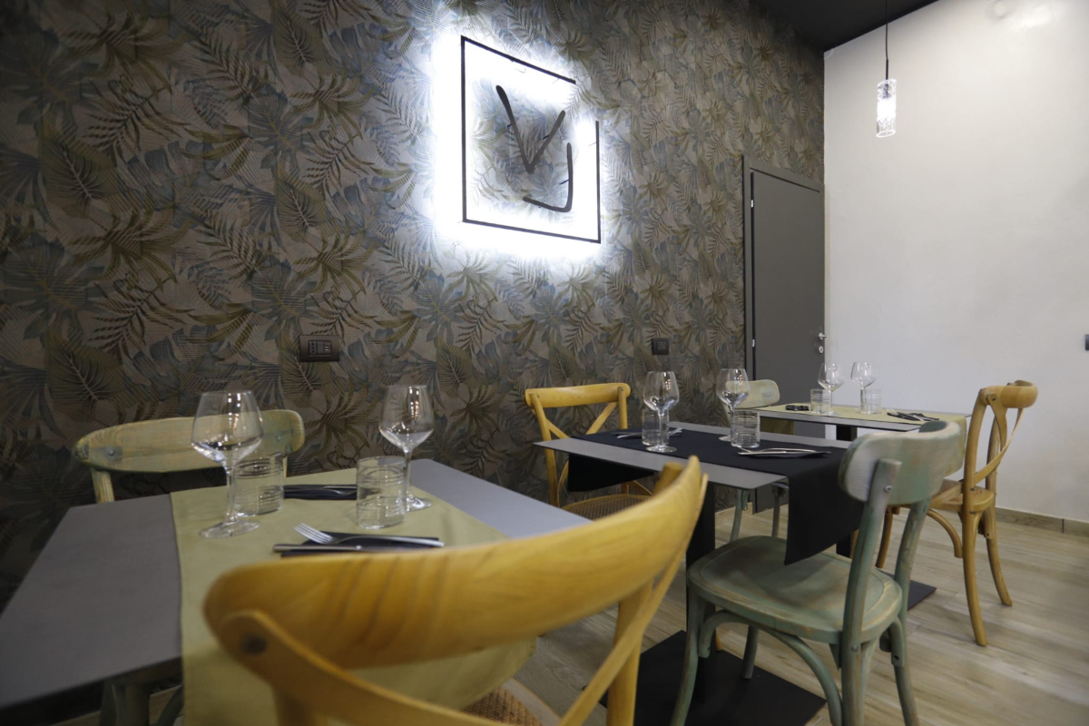 Voglia Trattoria Contemporanea, tavoli apparecchiati, sedie e insegna | LocaliArreda