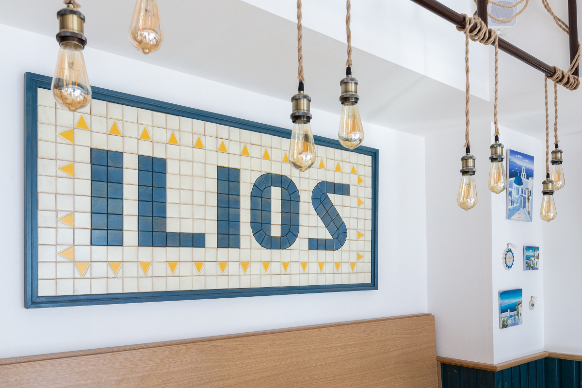 ristorante greco Ilios Pita insegna interna mattonelle mosaico e illuminazione vintage