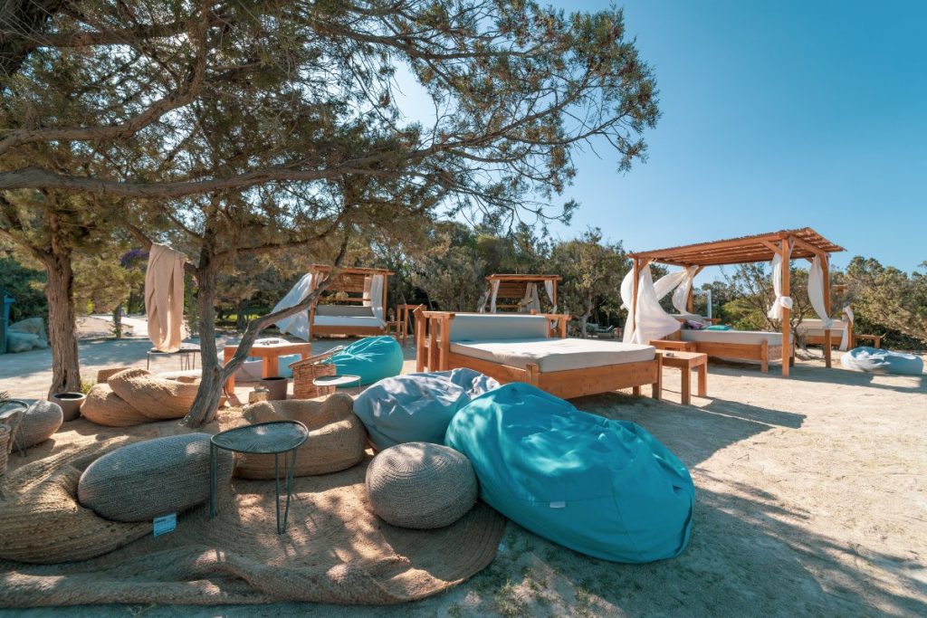 Ristorante, Lido, Stabilimento balneare The Bay (Costa Smeralda) gazebo, pouf azzurri e lettini in legno sulla spiaggia