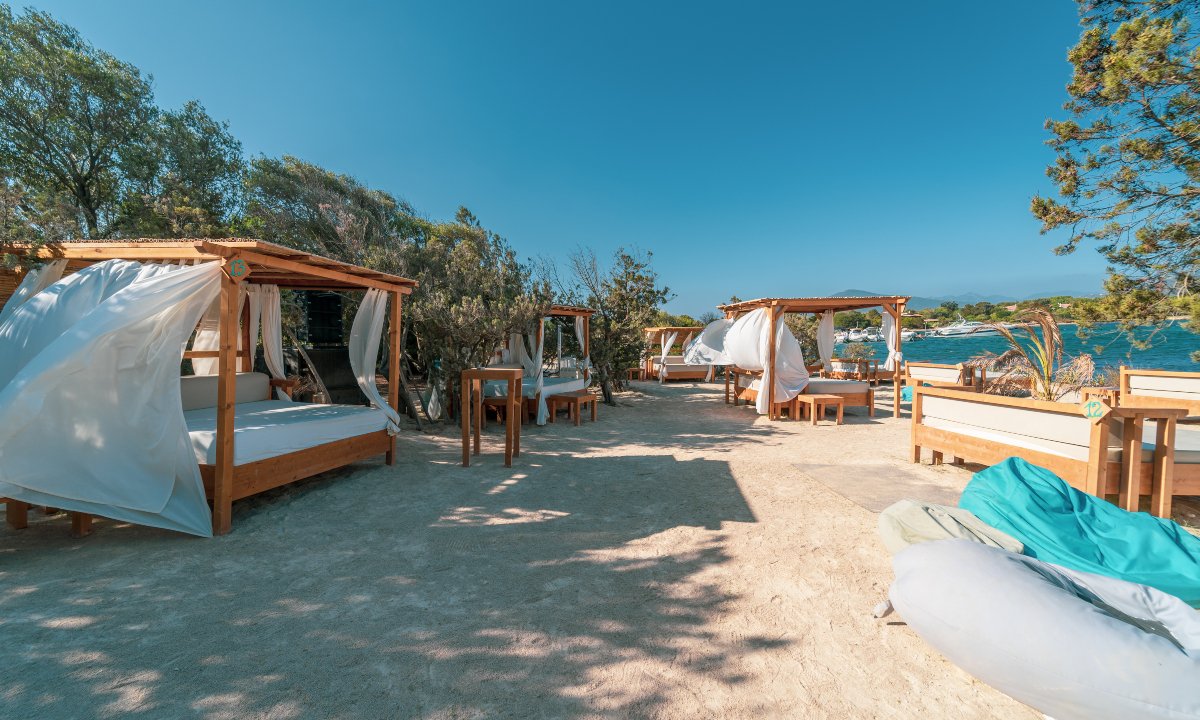 Ristorante, Lido, Stabilimento balneare The Bay (Costa Smeralda) gazebo in legno con tela bianca sulla spiaggia