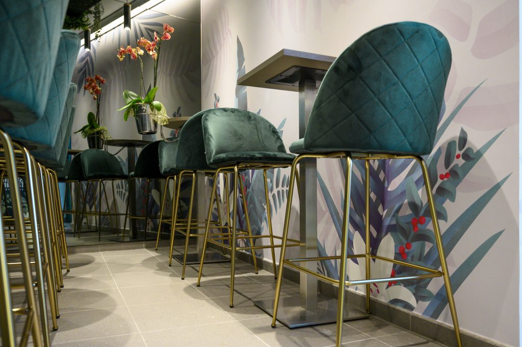 locale con stampe floreali e sgabelli poltroncine