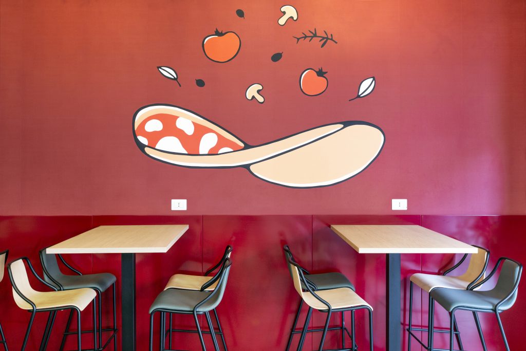 Pizzeria Mamma Pizza a Roma tavolini con sedie e parete decorata