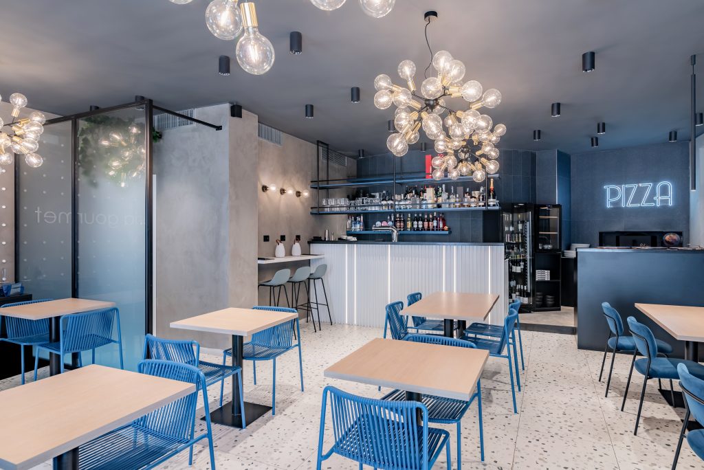 Pizzeria Etoile Roma Sala con tavolini e sedie blu bancone
