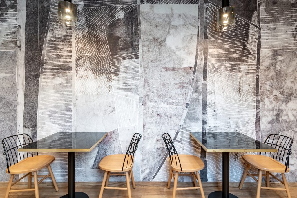 Bar caffetteria BU.MAR tavoini e sedie parete decorata