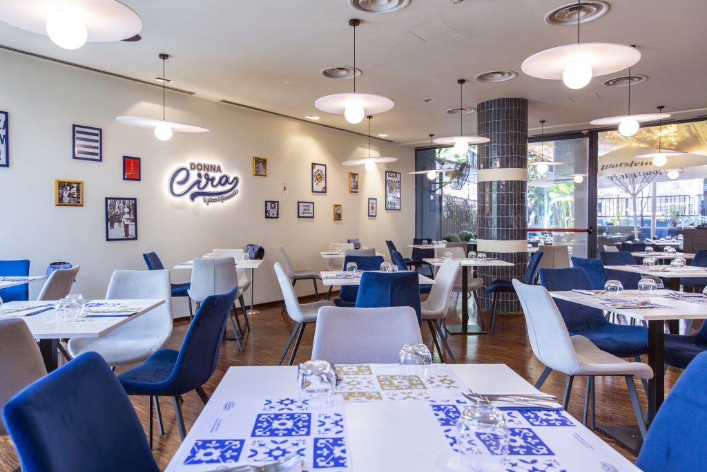 Pizzeria Donna Cira sala con sedie bianche blu luci a sospensione