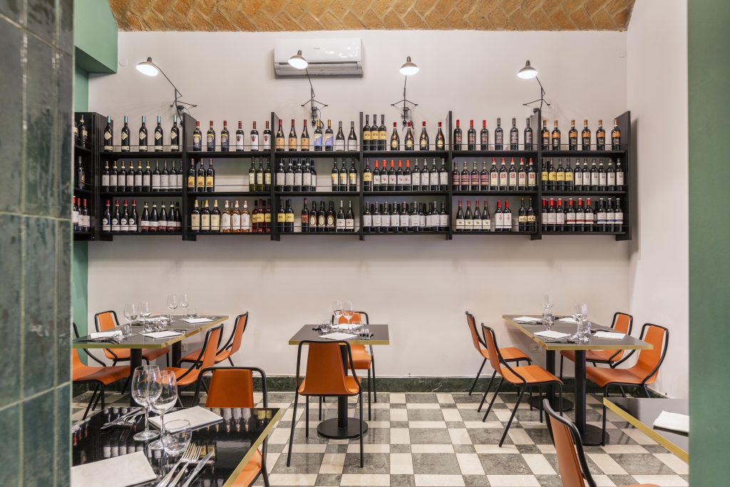 Ristorante Emasi tavolini con sedie bottiglie di vino
