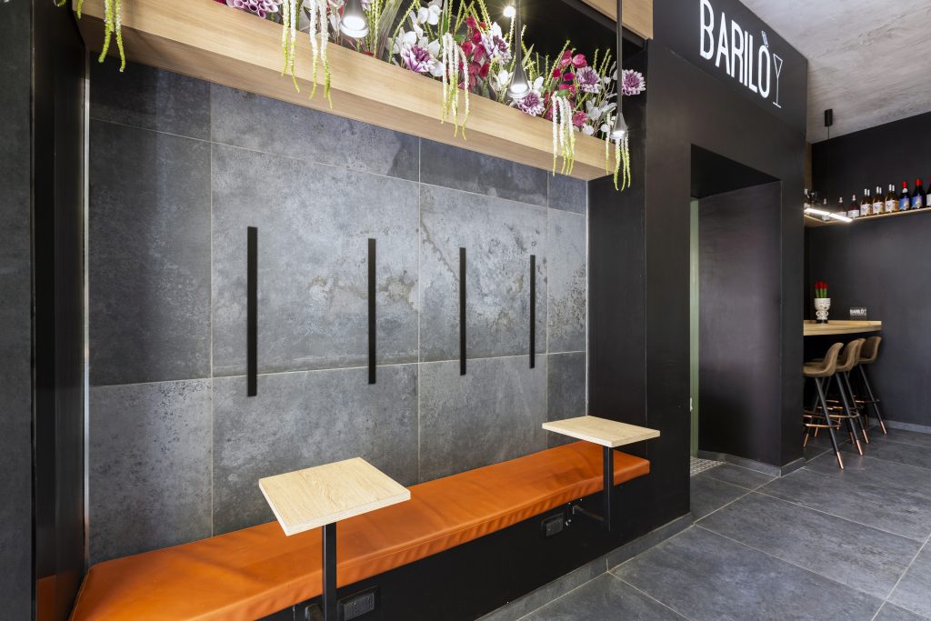 Interior of an industrial-style cocktail bar with orange benches
