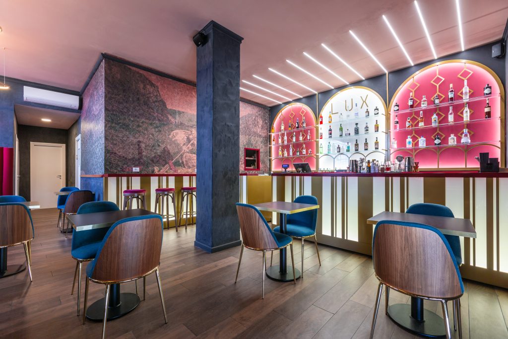 Lux cocktail bar room with tables and chairs, parquet, bottle display